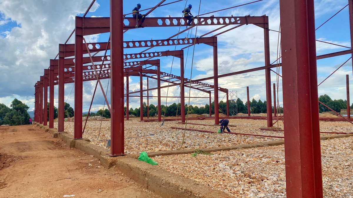 Ouvriers assemblant la charpente métallique d'un bâtiment industriel